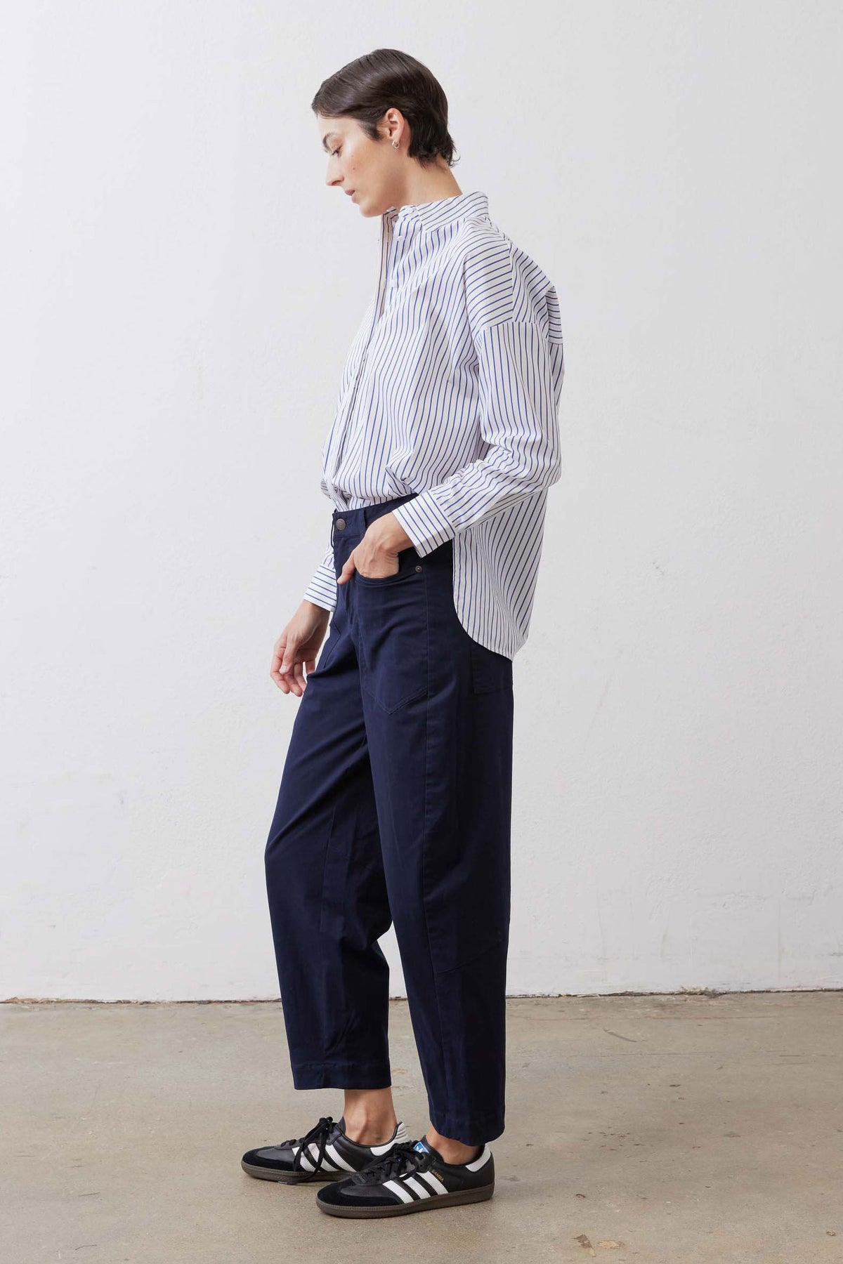 White and navy striped oversized tunic from side/back view with long cuffed sleeves