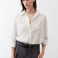 White oversized tunic with small black dot print, button-front collar and long sleeves