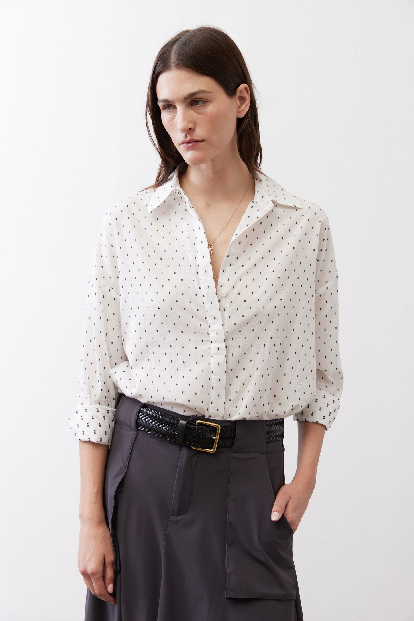 White oversized tunic with small black dot print, button-front collar and long sleeves