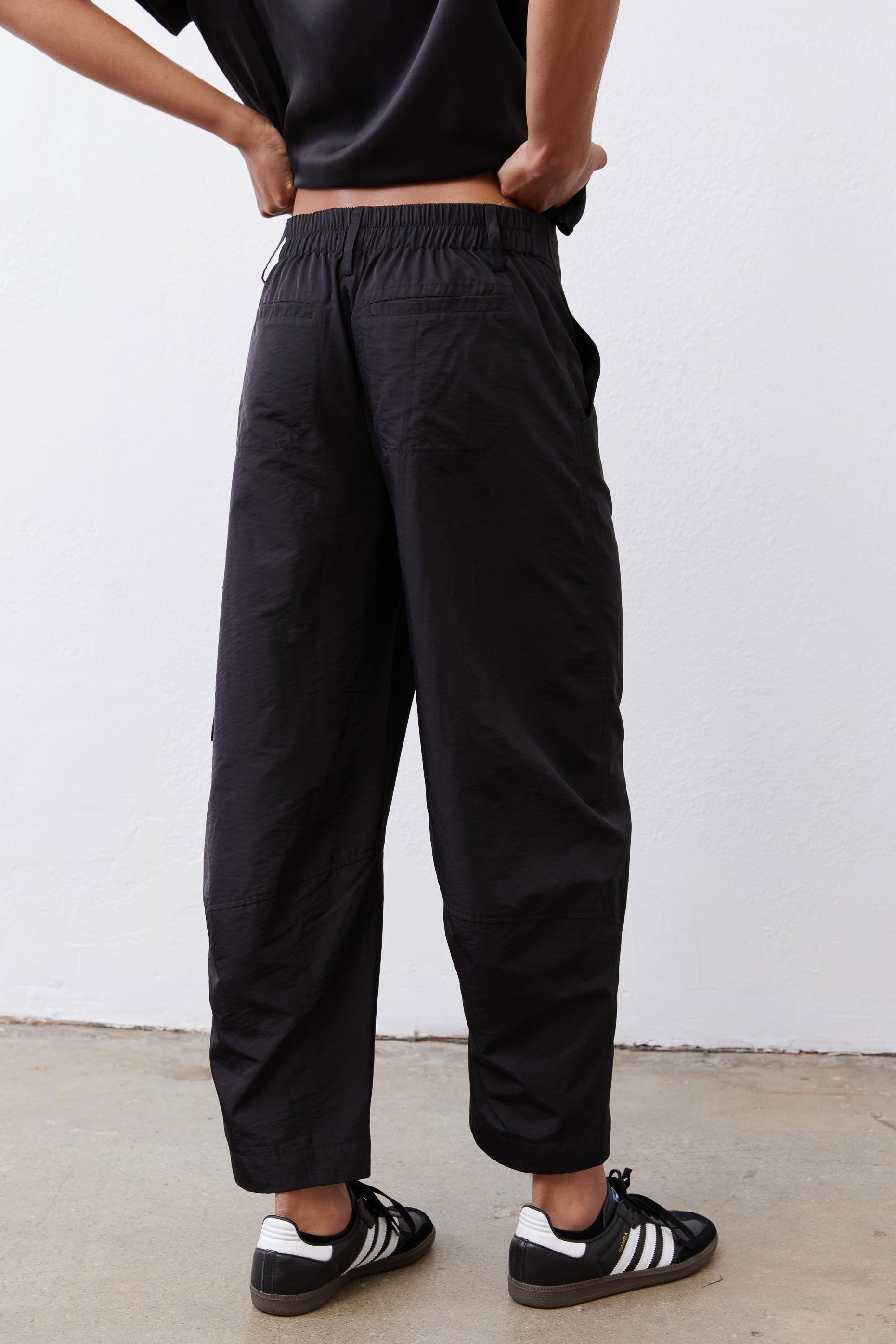 Black cargo barrel pants with elastic waist and relaxed barrel-leg shape