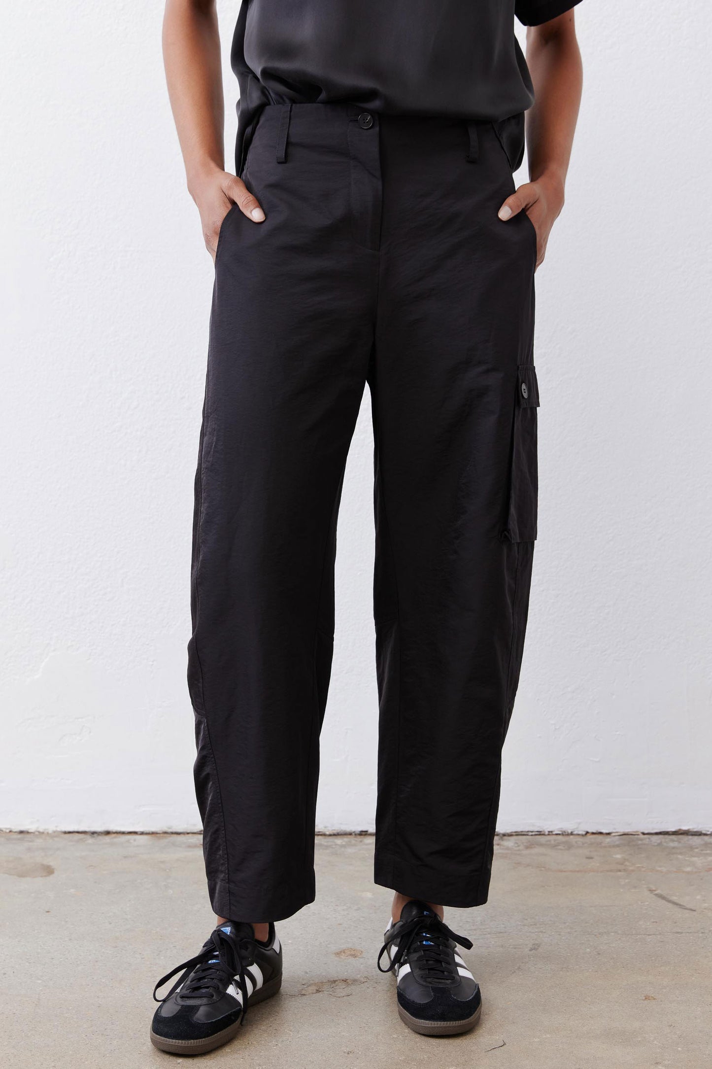 Black cargo barrel pants with cargo pocket panels and ankle-length relaxed fit