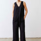 Black relaxed wide-leg sleeveless jumpsuit with V-neck and white side stripe, full front