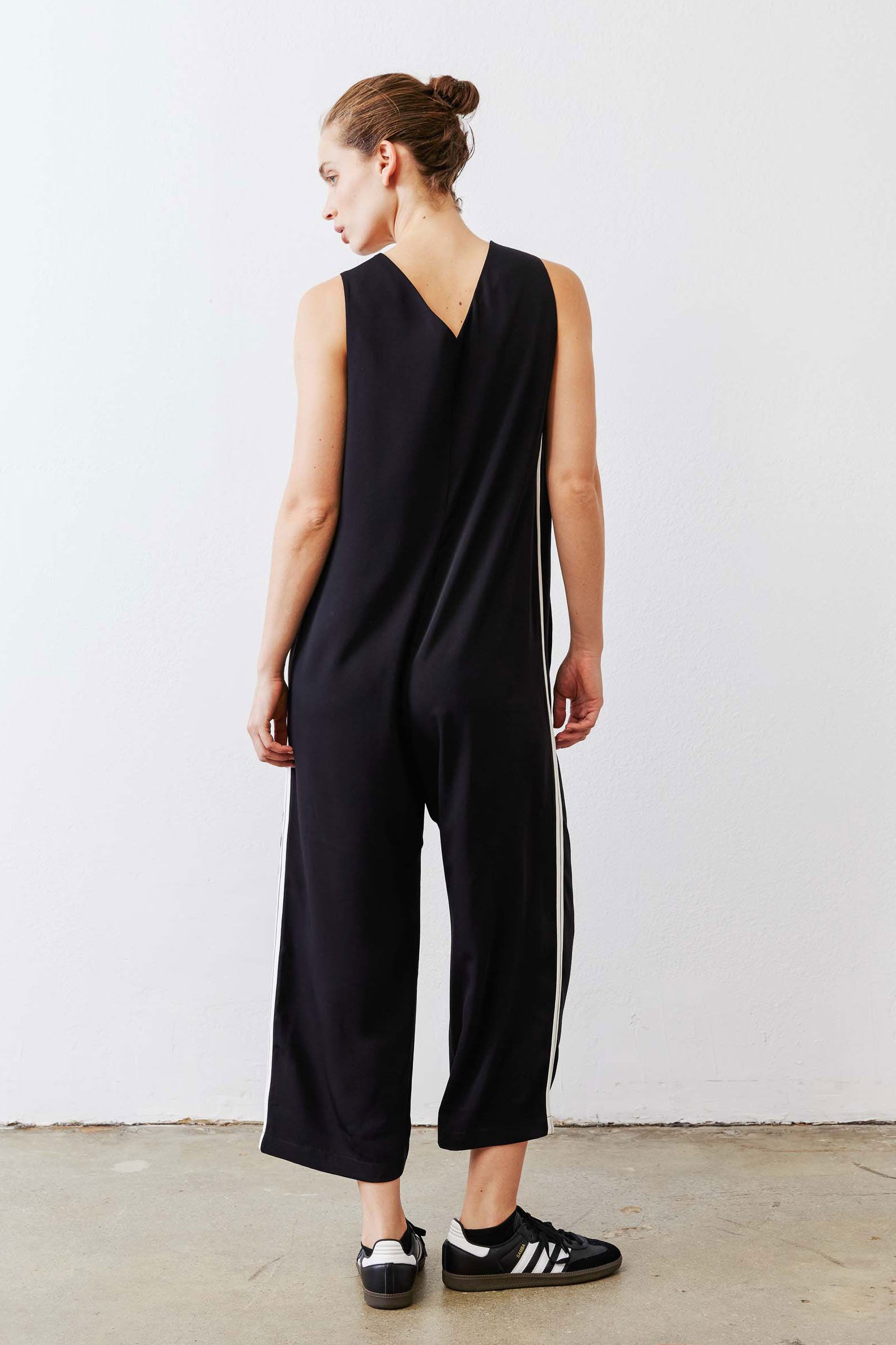 Black relaxed wide-leg sleeveless jumpsuit with white side stripe, back view