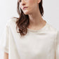 Ivory silk top close-up showing crew neck and short sleeves