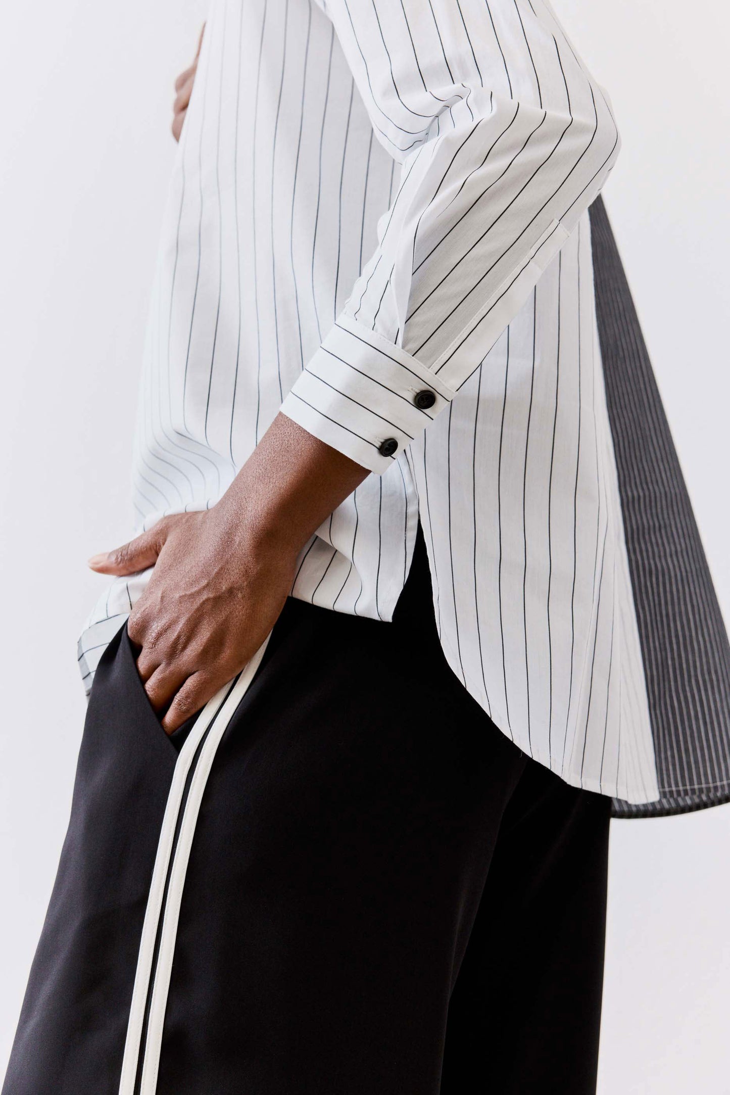 Striped button-down blouse with vertical light gray and white lines, button placket