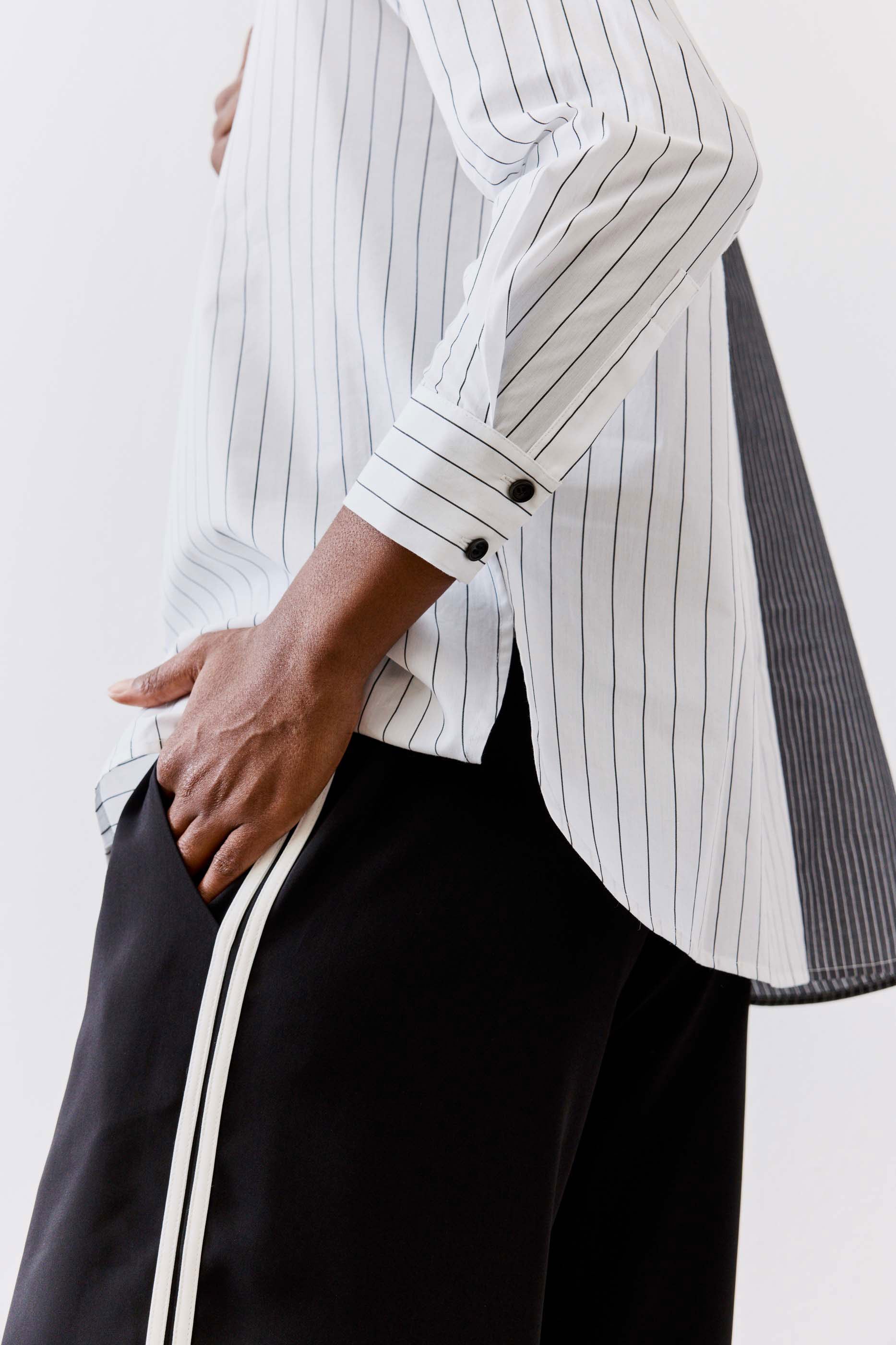 Striped button-down blouse with vertical light gray and white lines, button placket