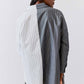Striped button-down blouse back view with vertical gray-and-white stripes and hem vent