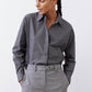Close-up of gray-and-white striped button-down blouse with button front and collar