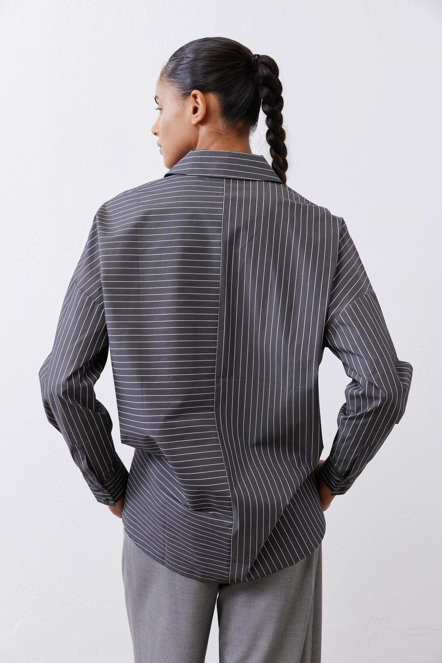 Back view of gray-and-white striped button-down blouse with long sleeves