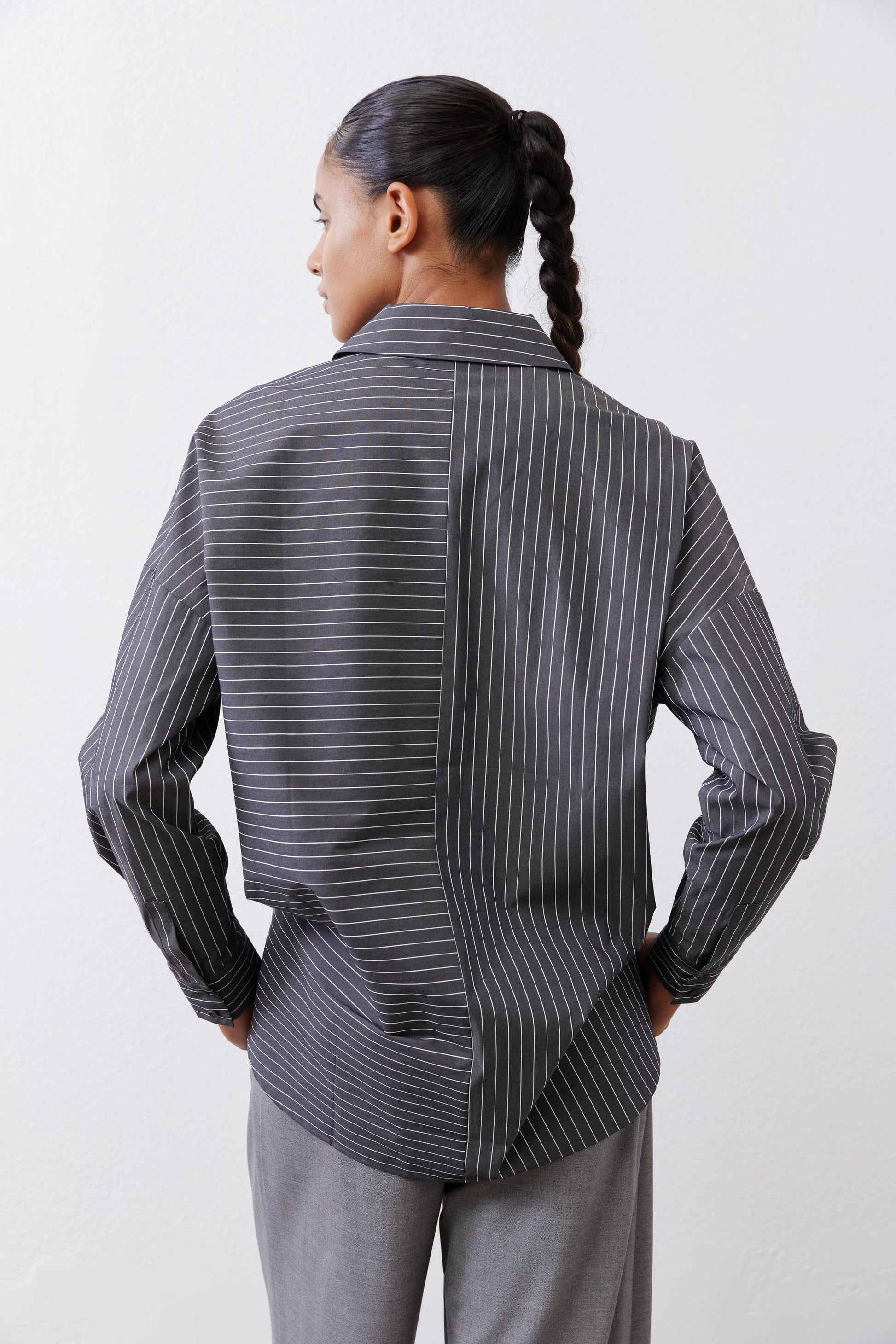 Back view of gray-and-white striped button-down blouse with long sleeves