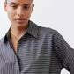 Close-up of gray-and-white striped button-down blouse with pointed collar
