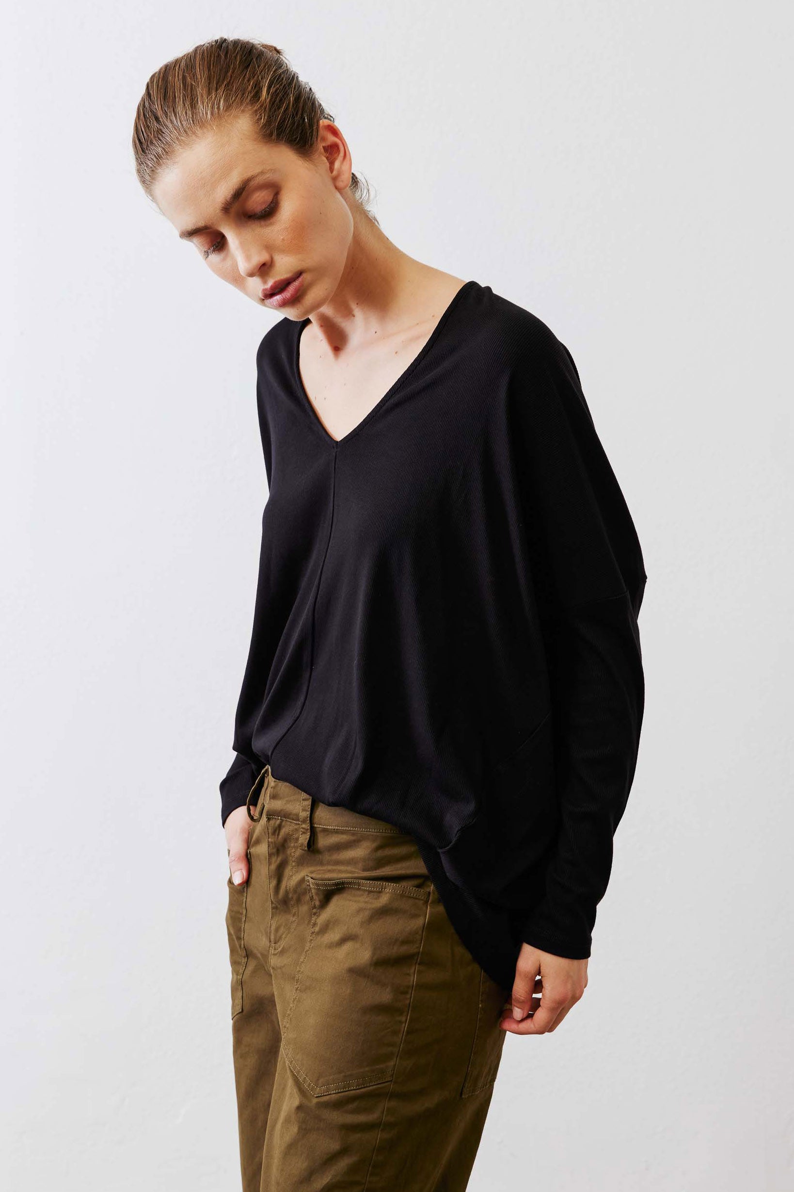 Black ribbed dolman long sleeve top, deep V-neck and side drape