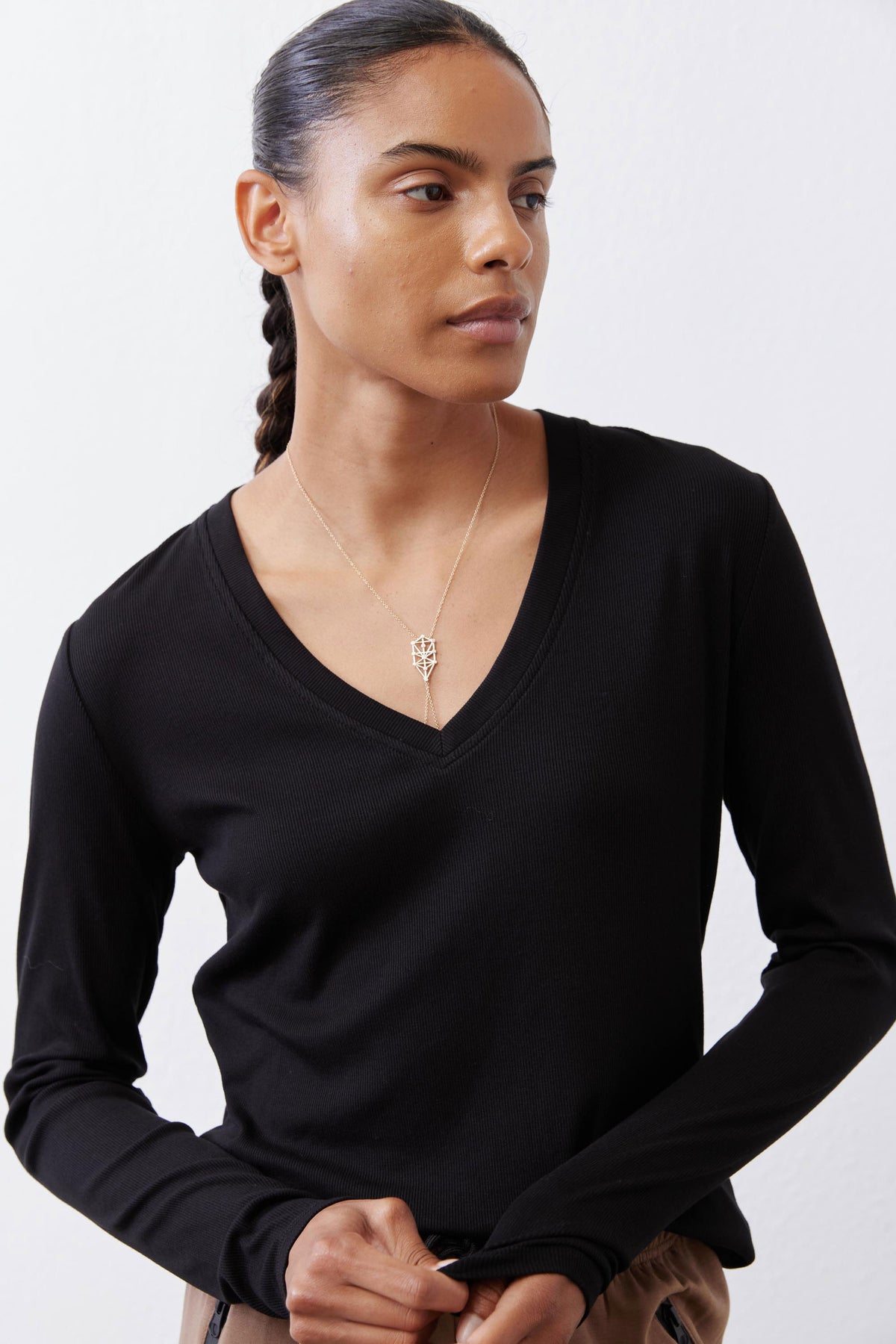 Black ribbed long-sleeve V-neck top, draped neckline and hem
