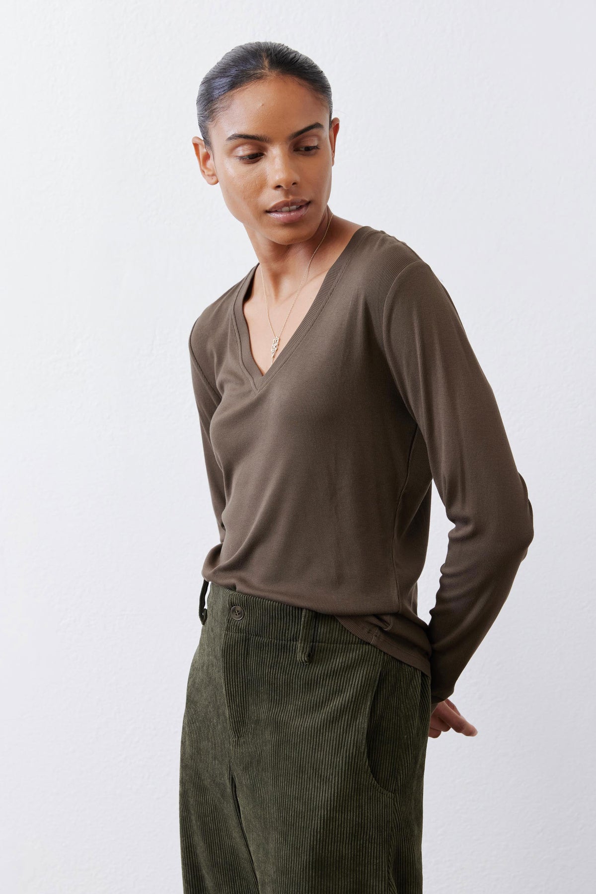 Olive-brown V-neck long-sleeve top with ribbed knit and relaxed drape