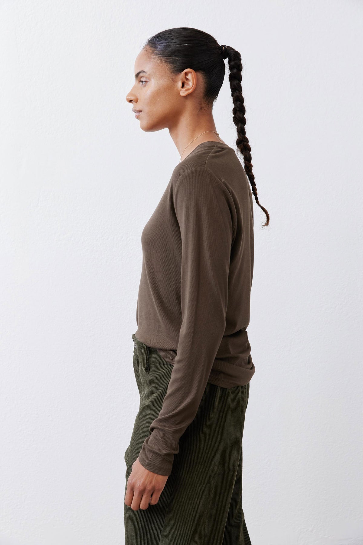 Olive-brown V-neck long-sleeve top, side view of sleeves