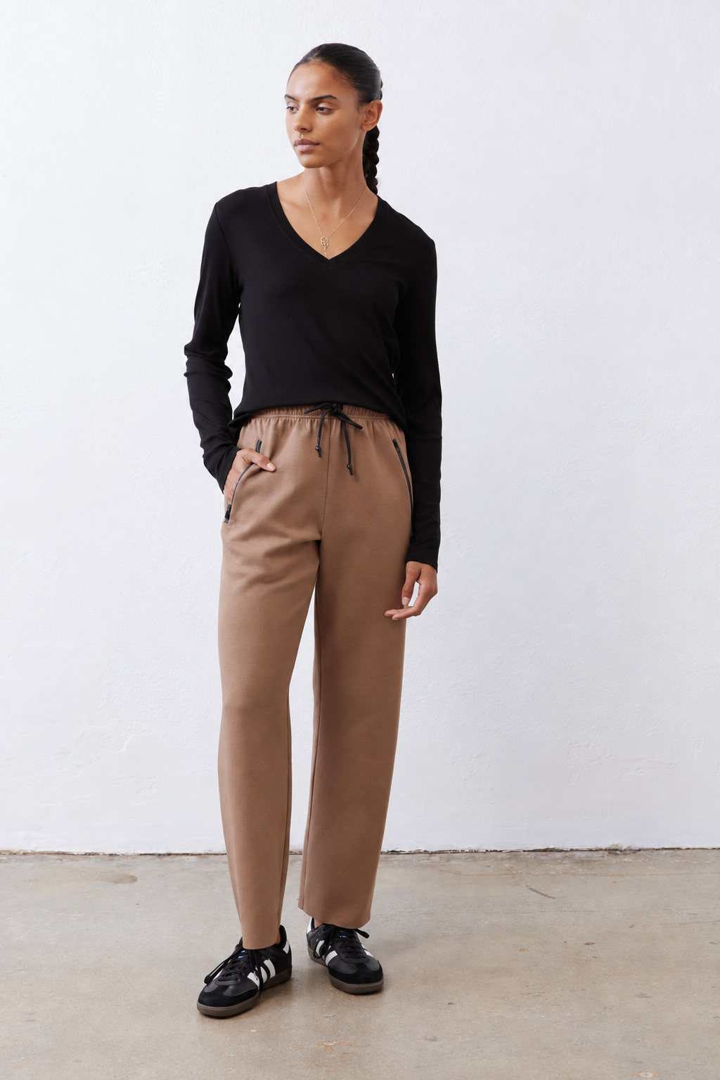 Black ribbed long-sleeve V-neck top, fitted with curved hem