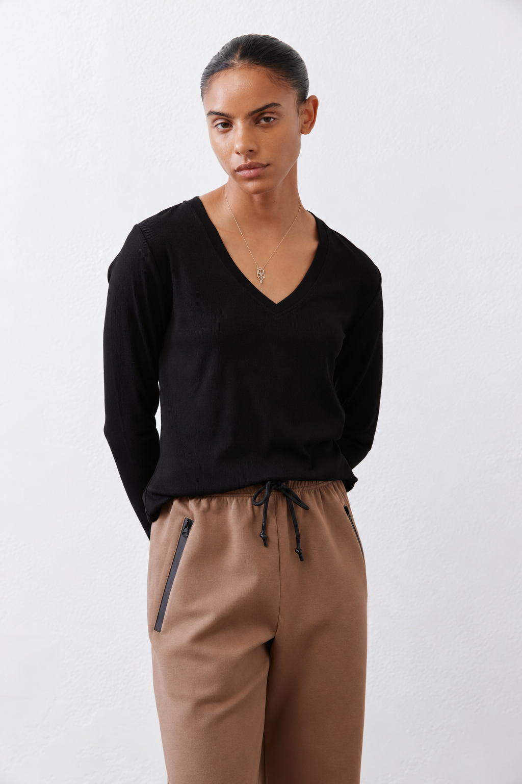 Black ribbed long-sleeve V-neck top with relaxed fit at the torso