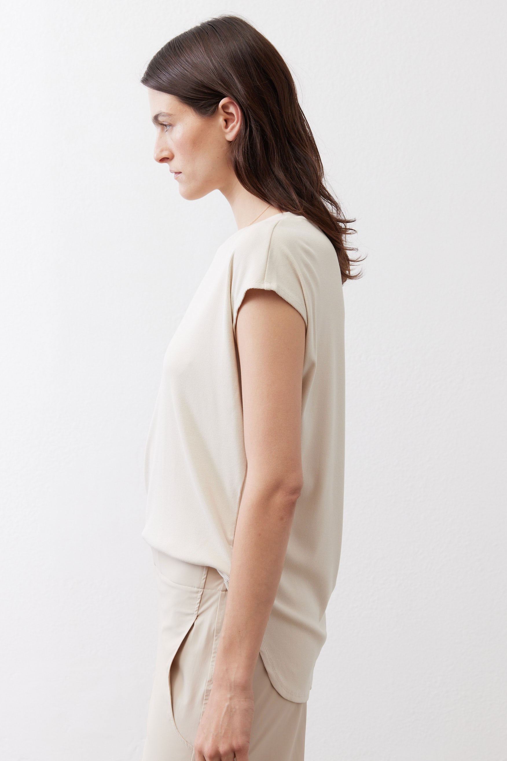 Light cream ribbed tee side view, short sleeves and draped hem