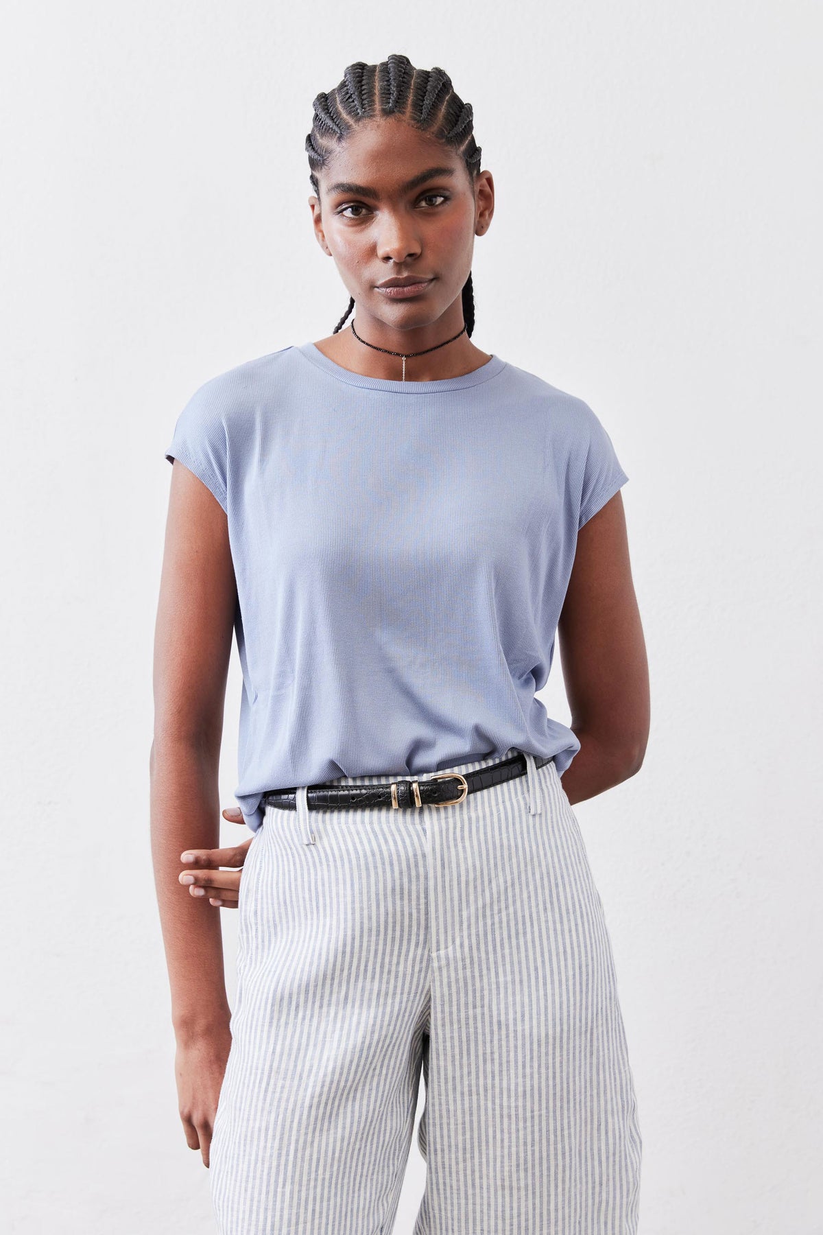 Light blue ribbed crew-neck tee with short sleeves, partially tucked