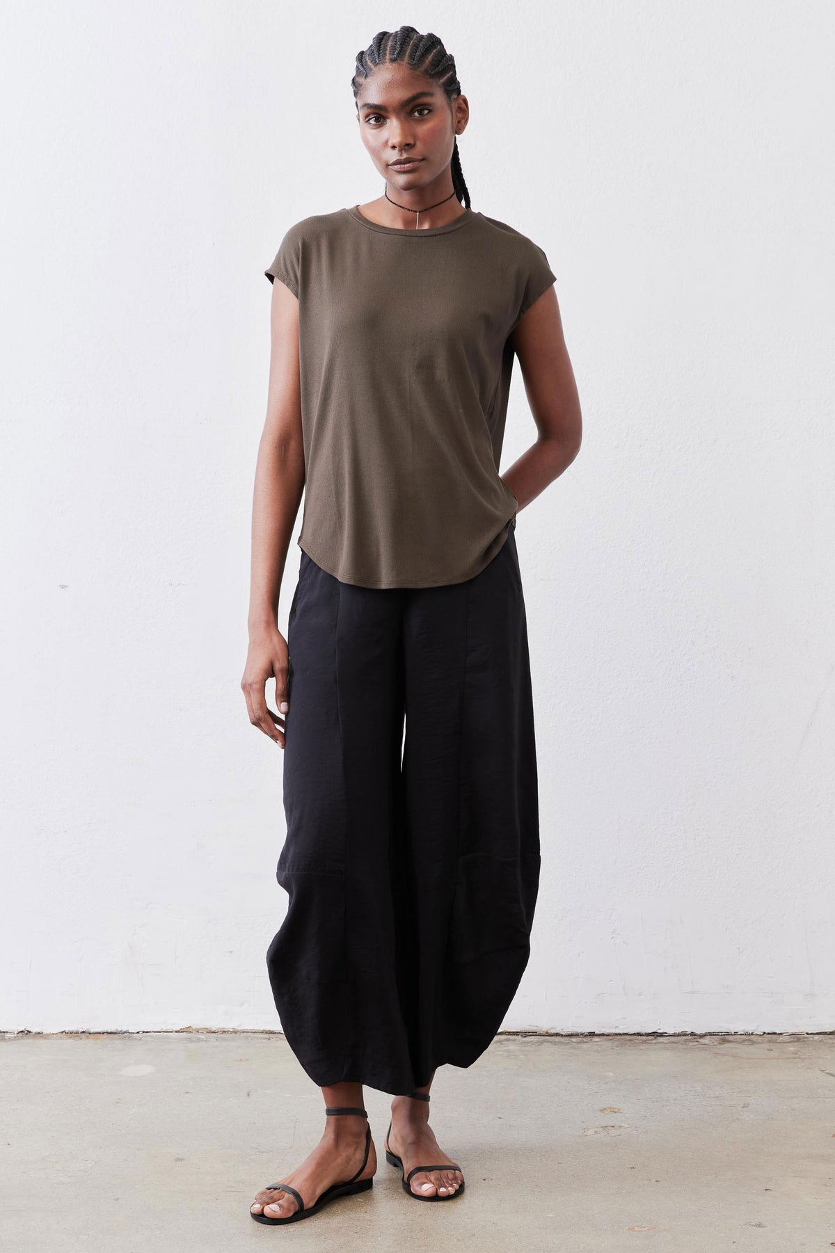 Olive crewneck short-sleeve tee with tucked hem and relaxed drape over dark pants