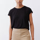 Black tuck-in tee with crew neck and short sleeves, worn with beige pants