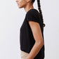 Black ribbed tuck-in tee with short sleeves, tucked into beige pants