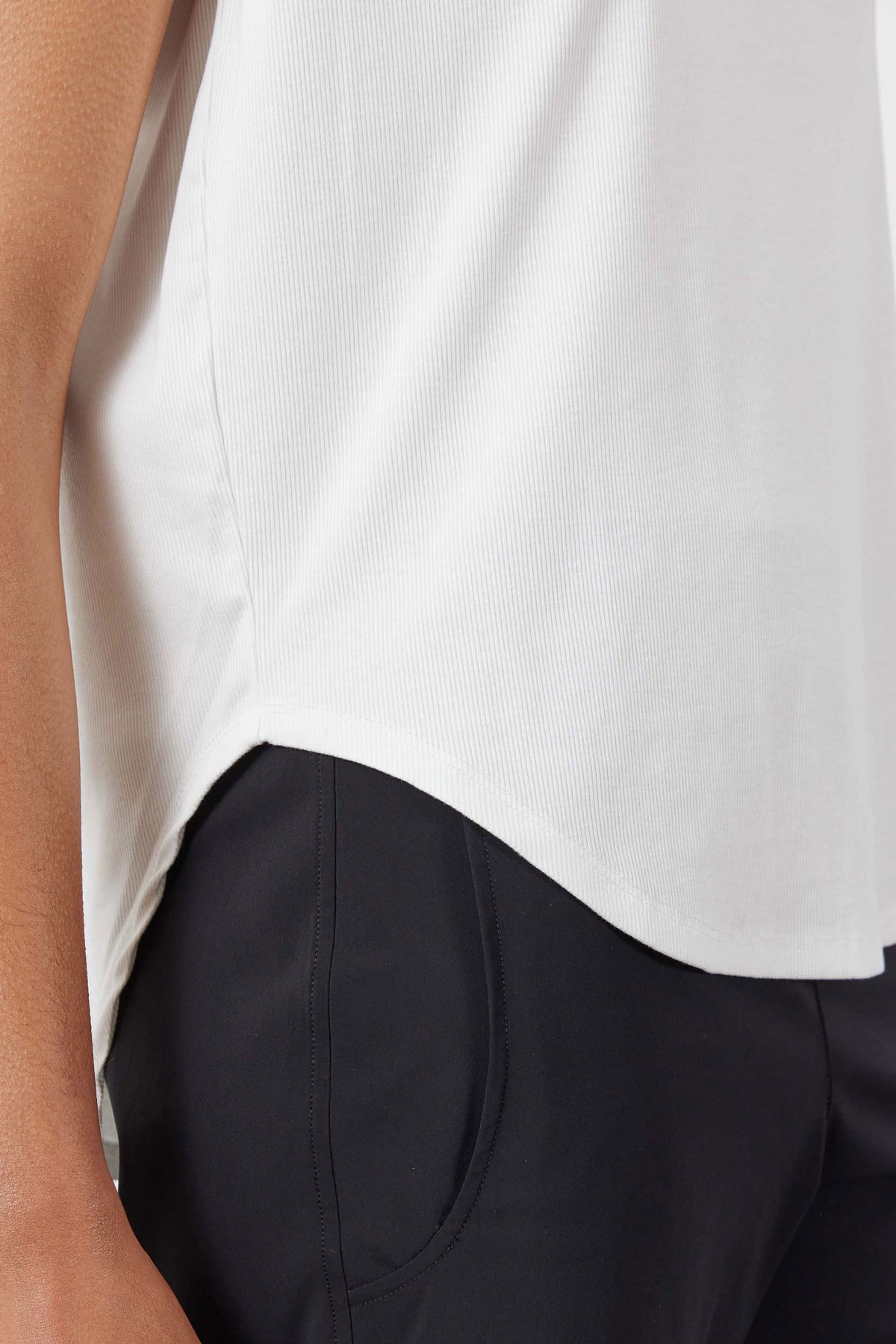 White ribbed tuck-in tee close-up of textured fabric and curved hem