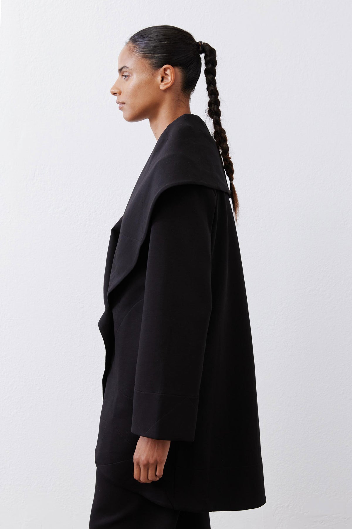 Black shawl-collar wrap coat with angled hem and long sleeves