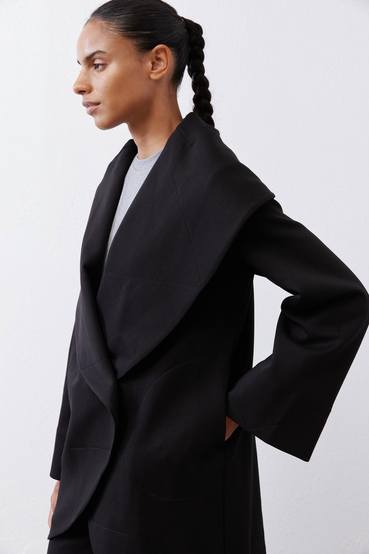 Black shawl-collar wrap coat with open front and long cuffed sleeves