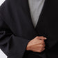 Black shawl-collar wrap coat detail with overlap front and matte finish