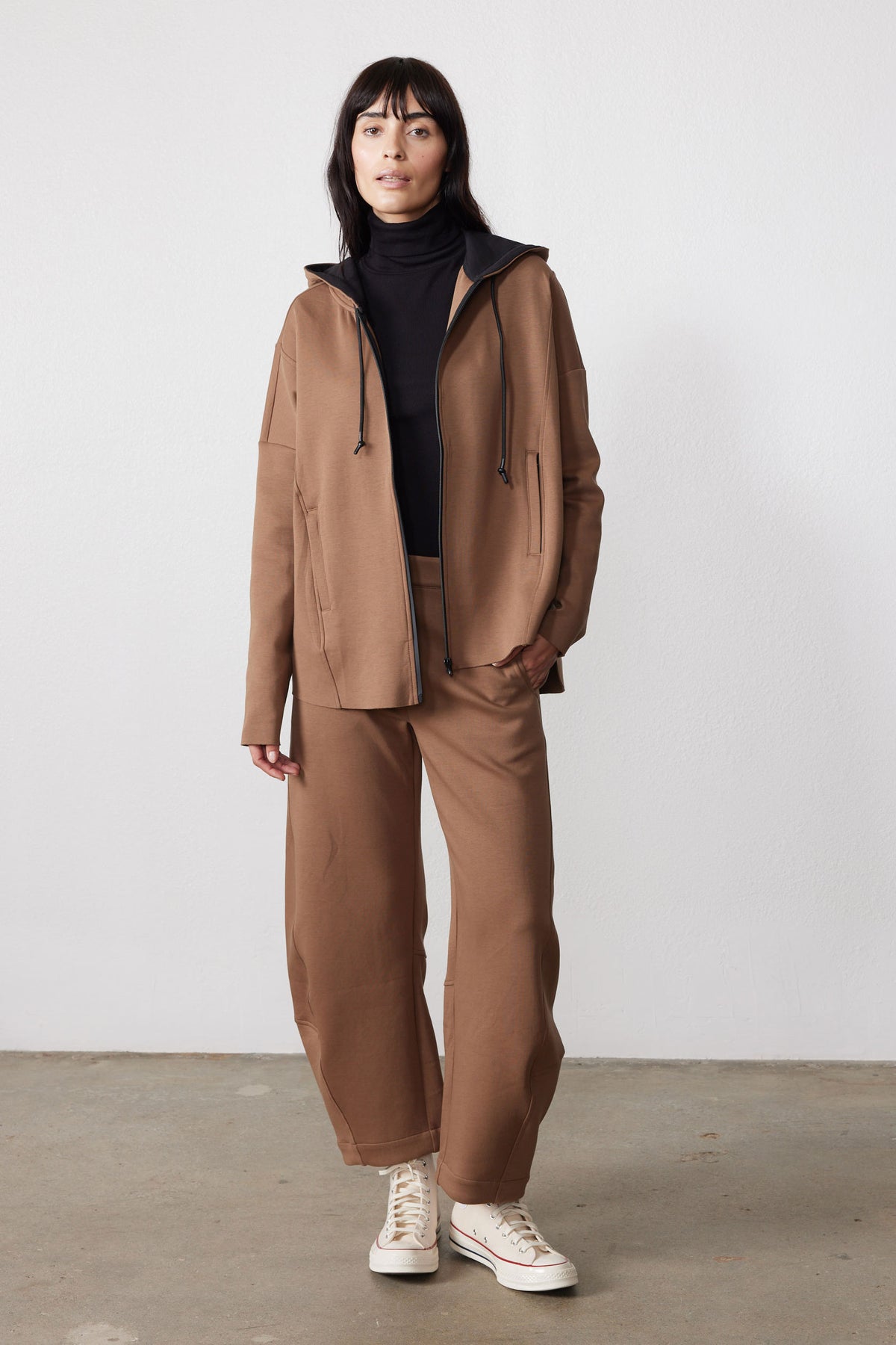 Mocha scuba zip hoodie with drawstring hood, worn open with matching wide-leg pants.