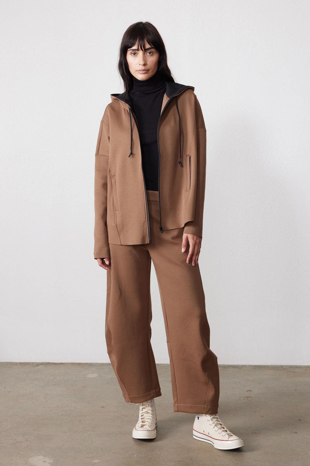 Mocha scuba zip hoodie worn open, showing its hood, front pockets, and relaxed fit.