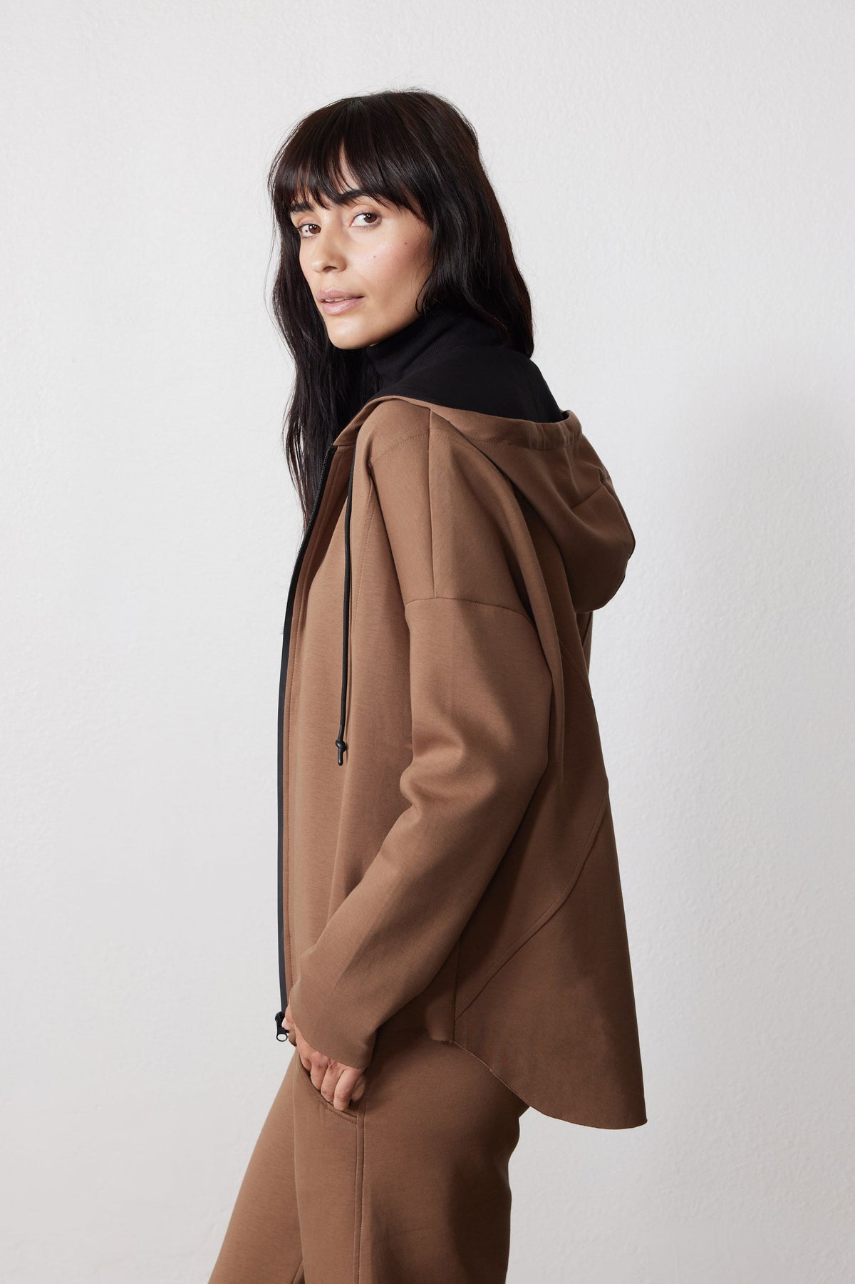 Side view of a mocha scuba zip hoodie with a relaxed fit and drawstring hood.