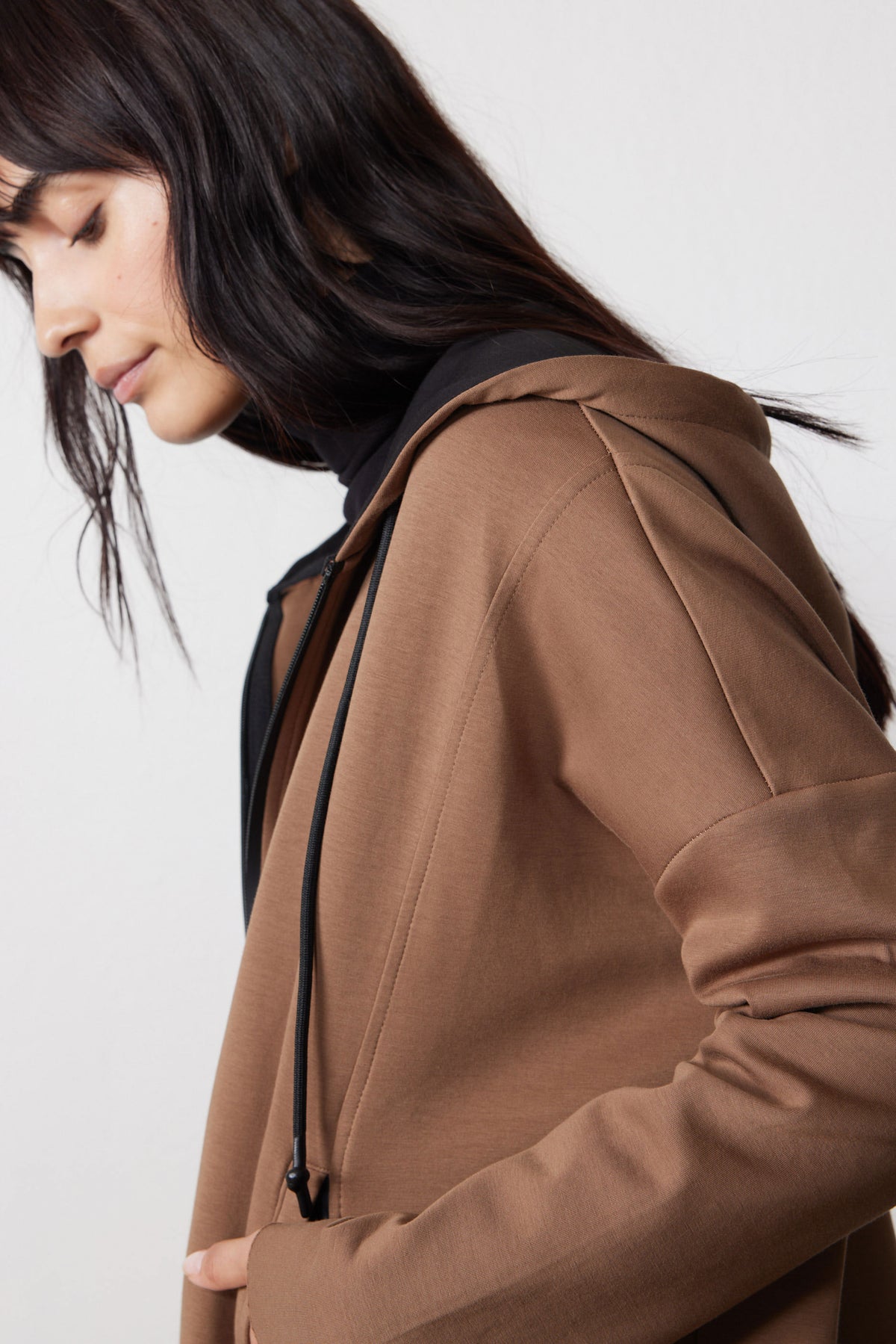 Close-up of the mocha scuba hoodie's shoulder seam, hood, and drawstring.