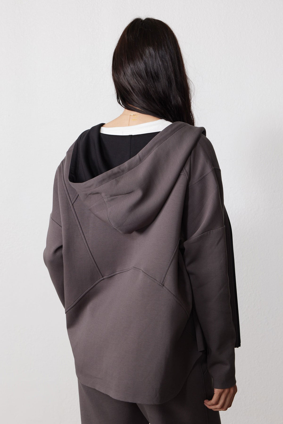 Back view of storm gray scuba hoodie with a draped hood and curved seam detail.