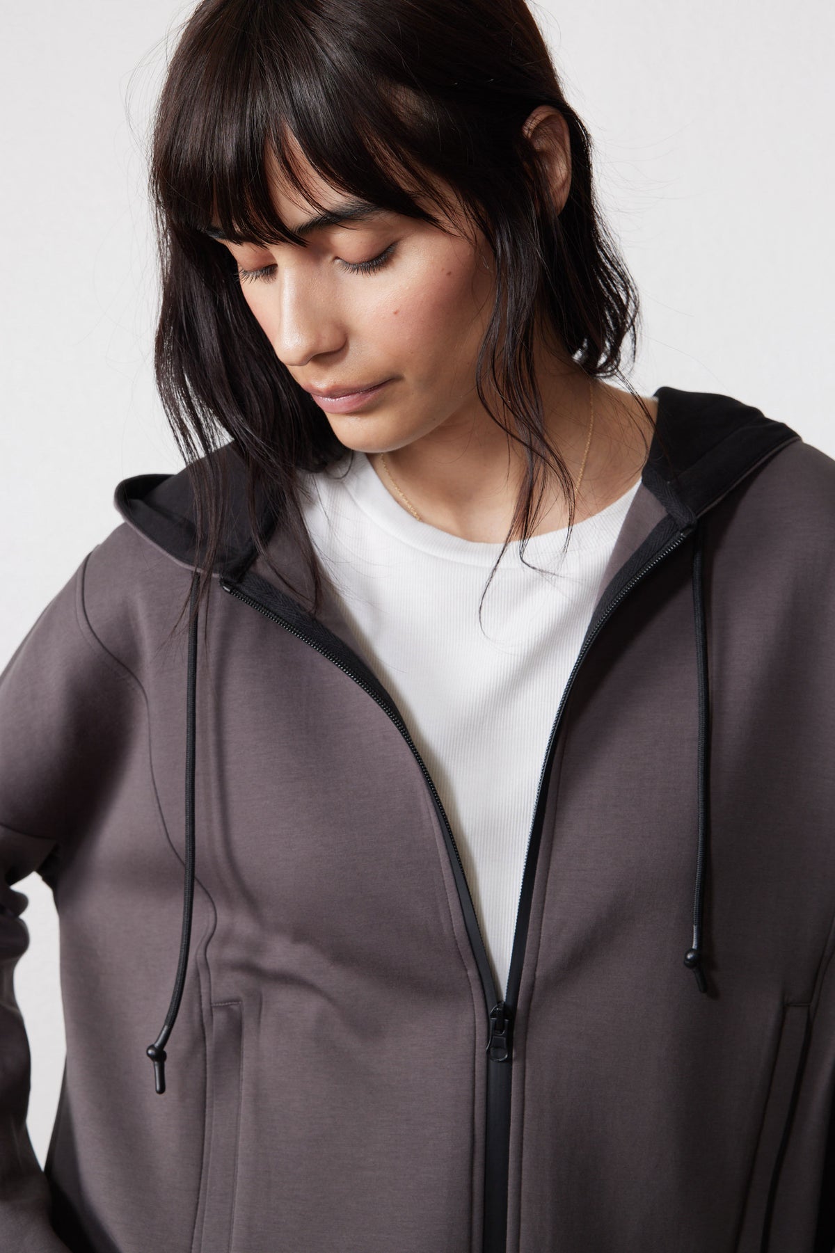 Close-up of storm gray hoodie showing the hood, drawstrings, and open zipper.