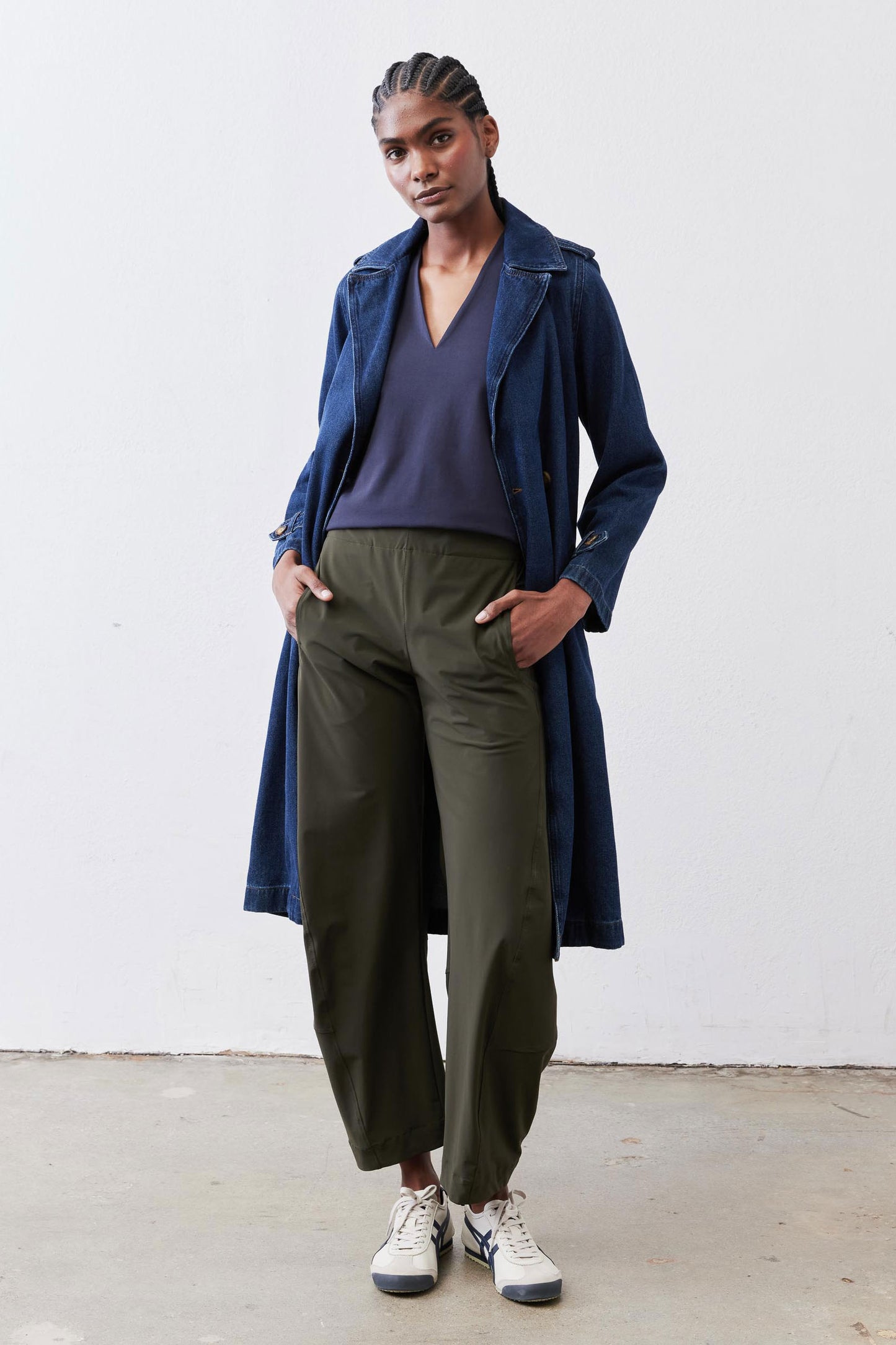 Deep blue V-neck sleeveless tank top under long navy jacket and olive trousers