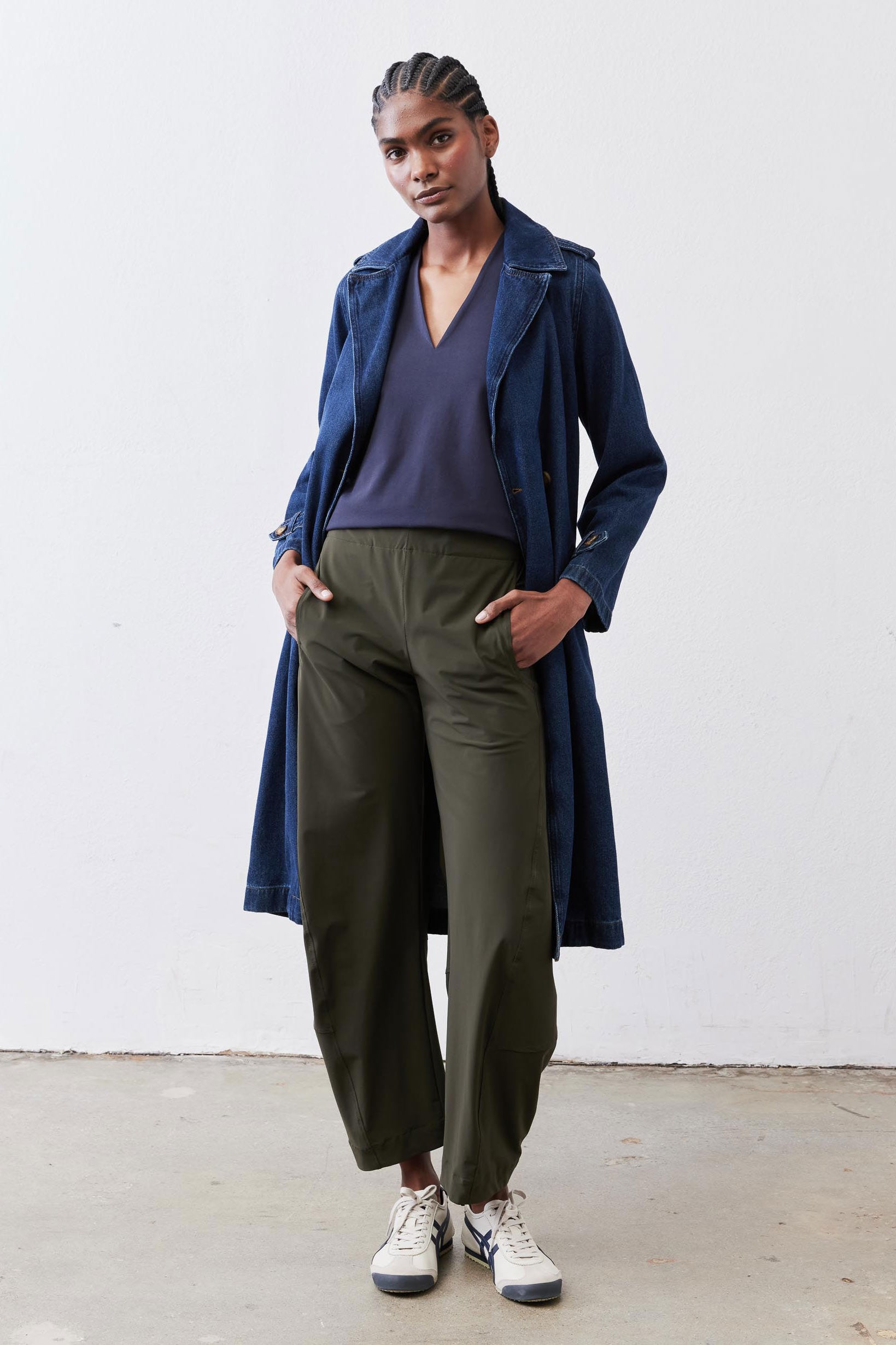 Deep blue V-neck sleeveless tank top under long navy jacket and olive trousers