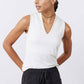 White sculpted V-neck tank top, sleeveless fitted silhouette, model side view