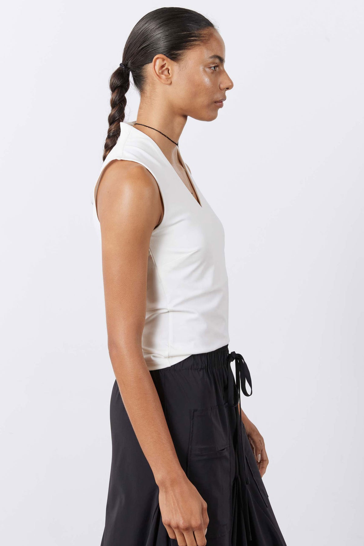White sleeveless V-neck tank top with fitted, sculpted shape