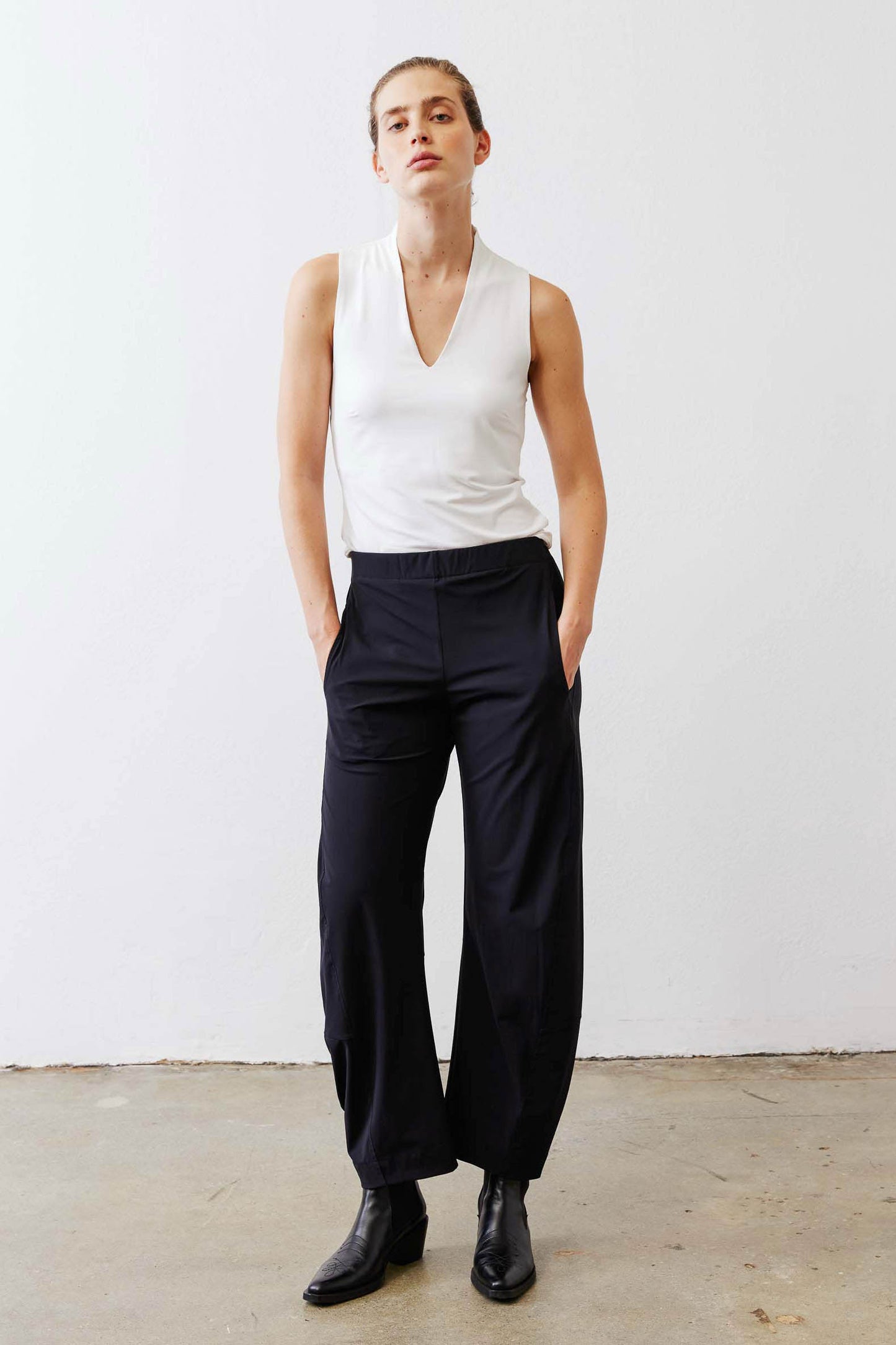 White sculpted V-neck tank top with black drawstring cargo pants