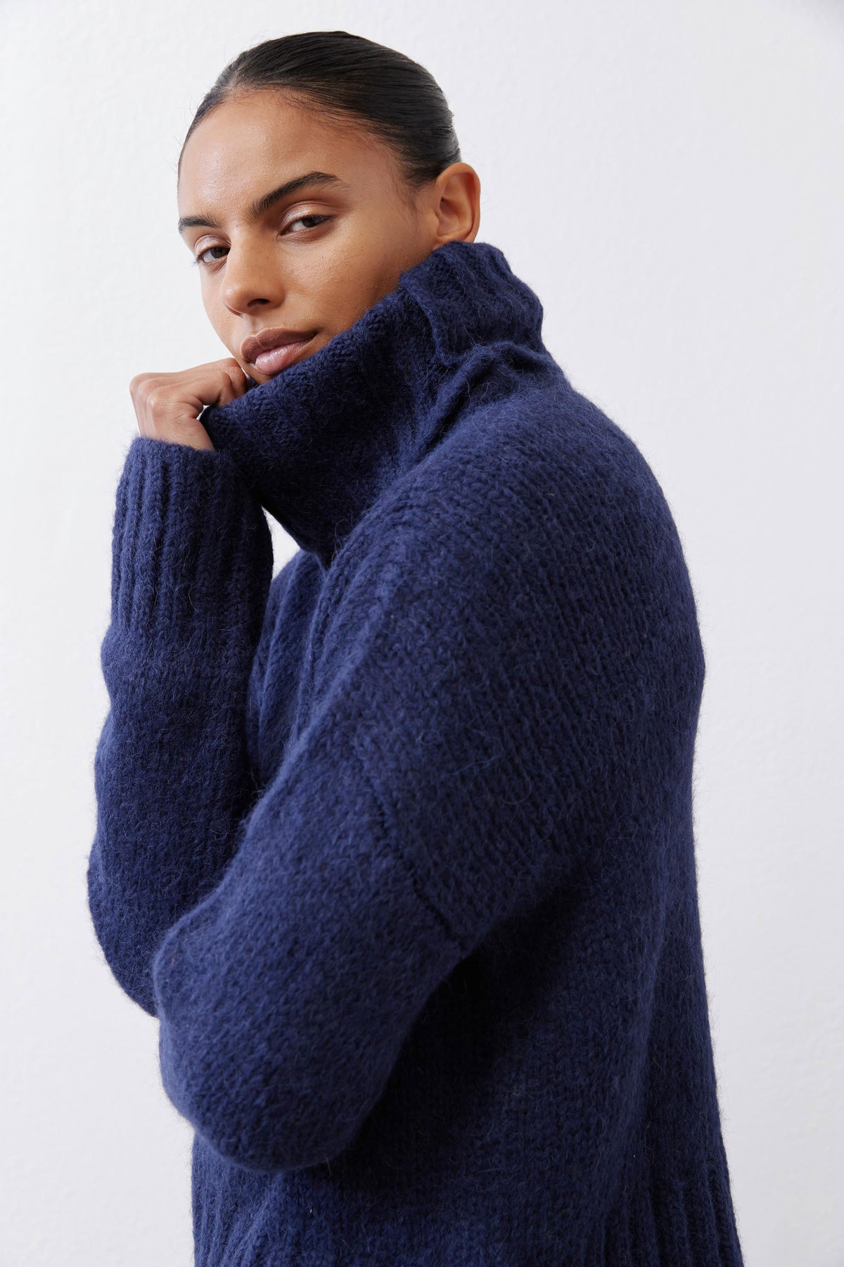 Midnight navy shawl-collar sweater with cozy knit texture, styled with a white layer