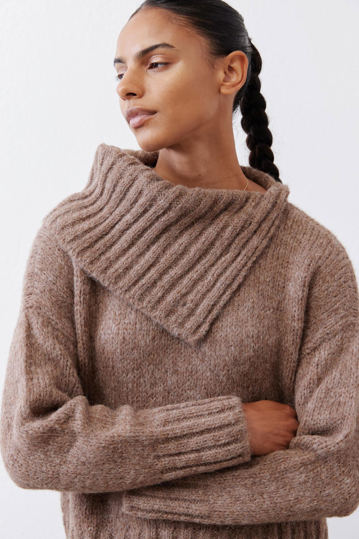 Taupe melange shawl-collar sweater with thick knit texture, arms crossed close-up.