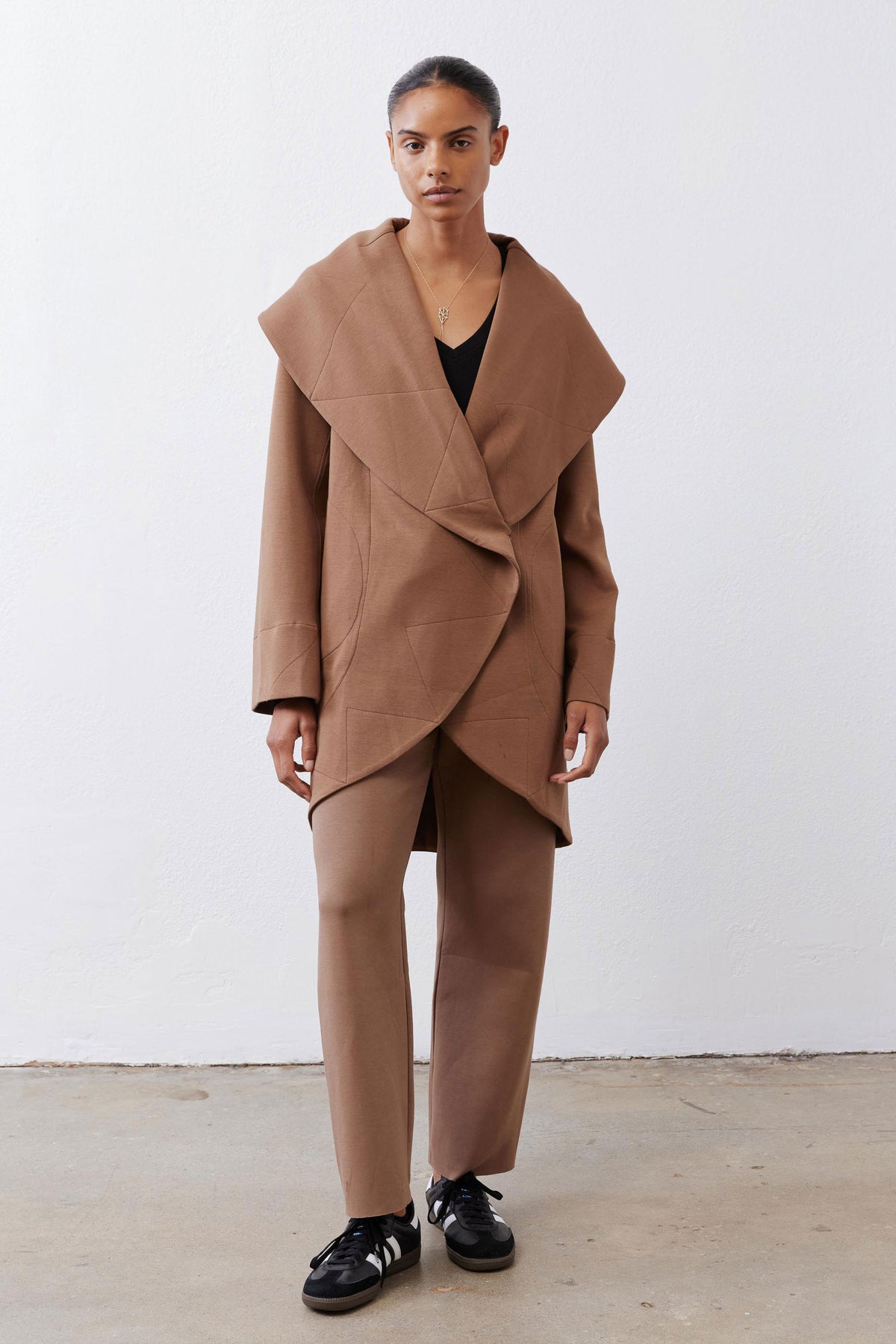 Fawn shawl-collar wrap coat with long sleeves, asymmetrical hem, and side pockets
