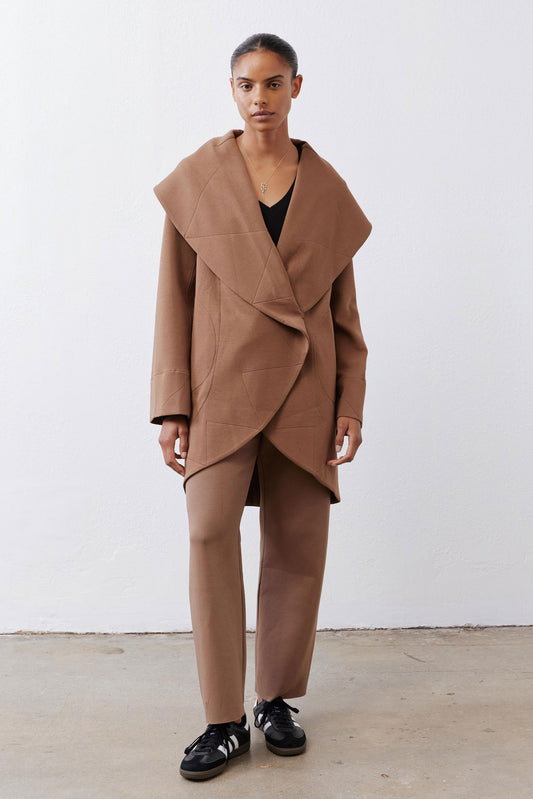 Fawn shawl-collar wrap coat with long sleeves, asymmetrical hem, and side pockets