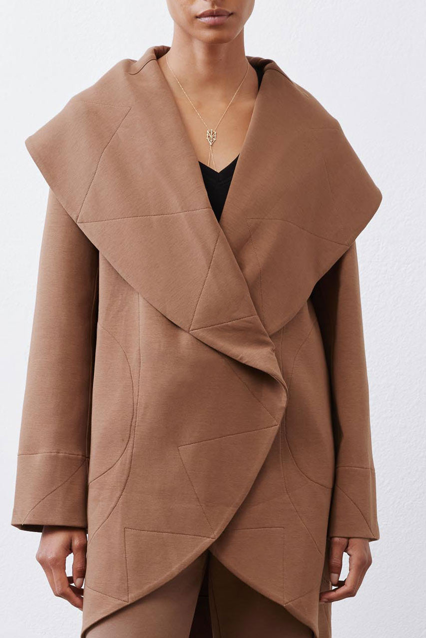 Fawn shawl-collar wrap coat detail with overlapping front and seam lines