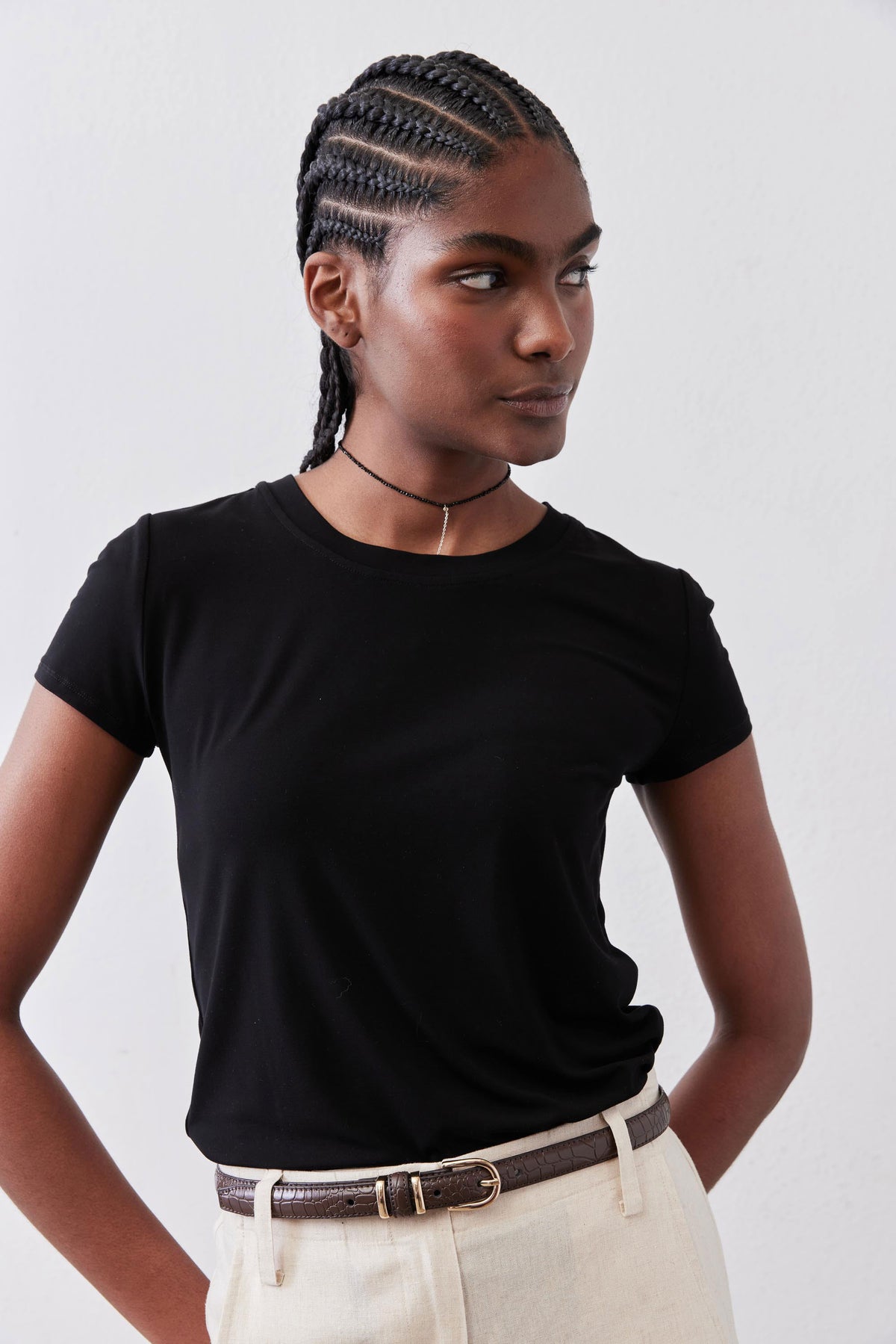 Black short-sleeve crew neck tee with drape across chest and fitted sleeves