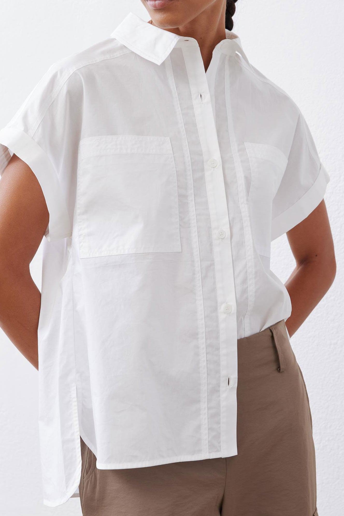 White poplin button-down blouse close-up with pointed collar and front patch pocket