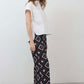 White short-sleeve button-down blouse with pointed collar and pleated front panel