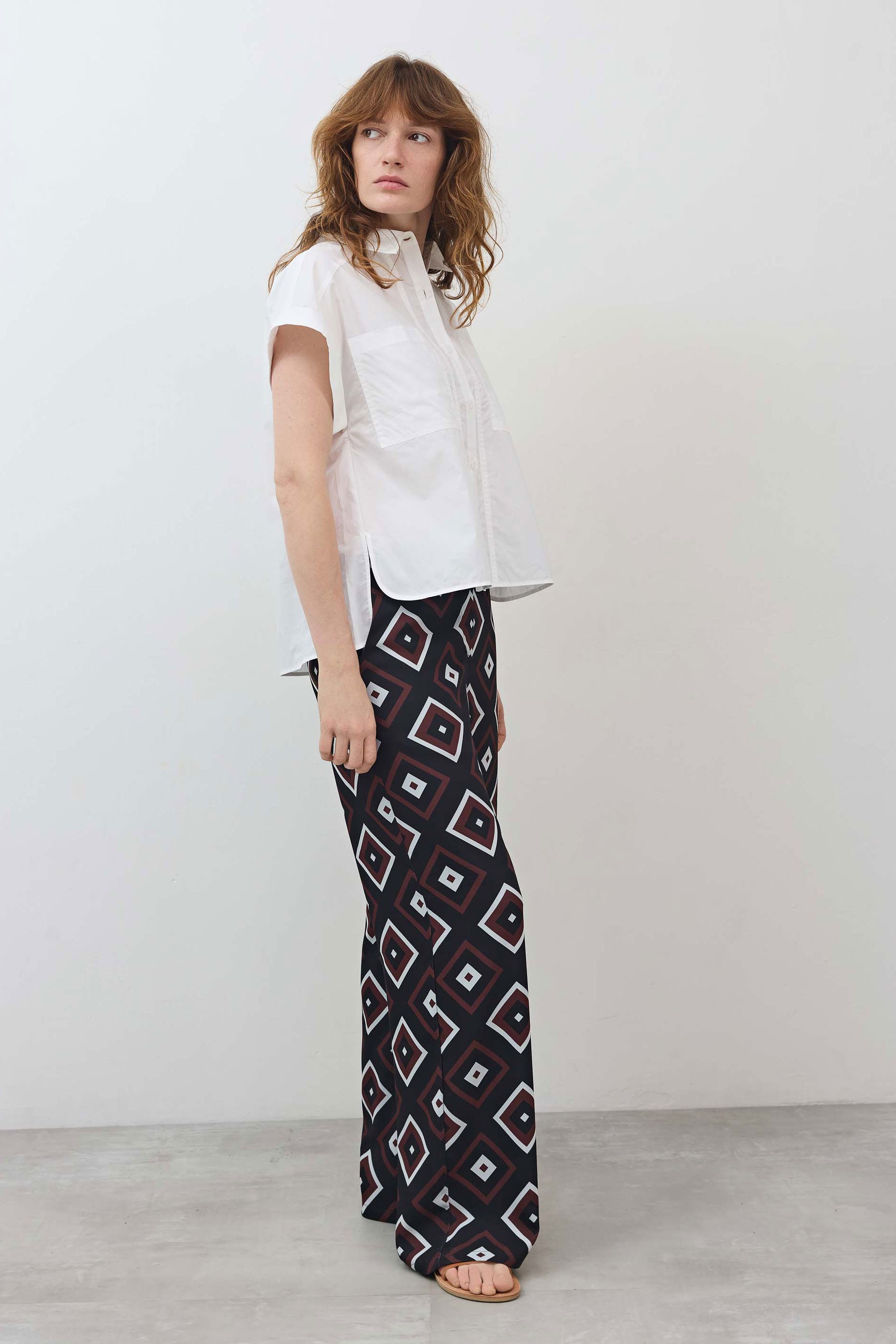 White short-sleeve button-down blouse with pointed collar and pleated front panel